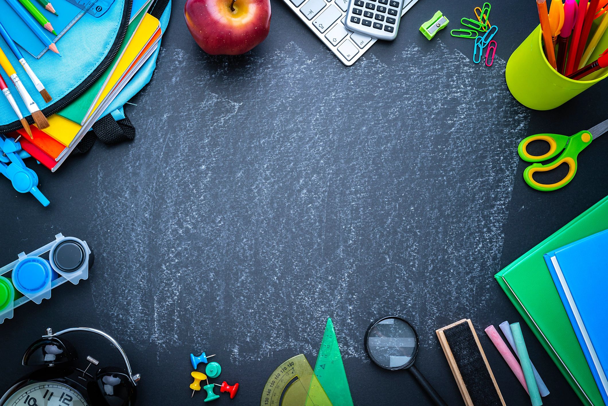 School or office supplies border on blackboard background