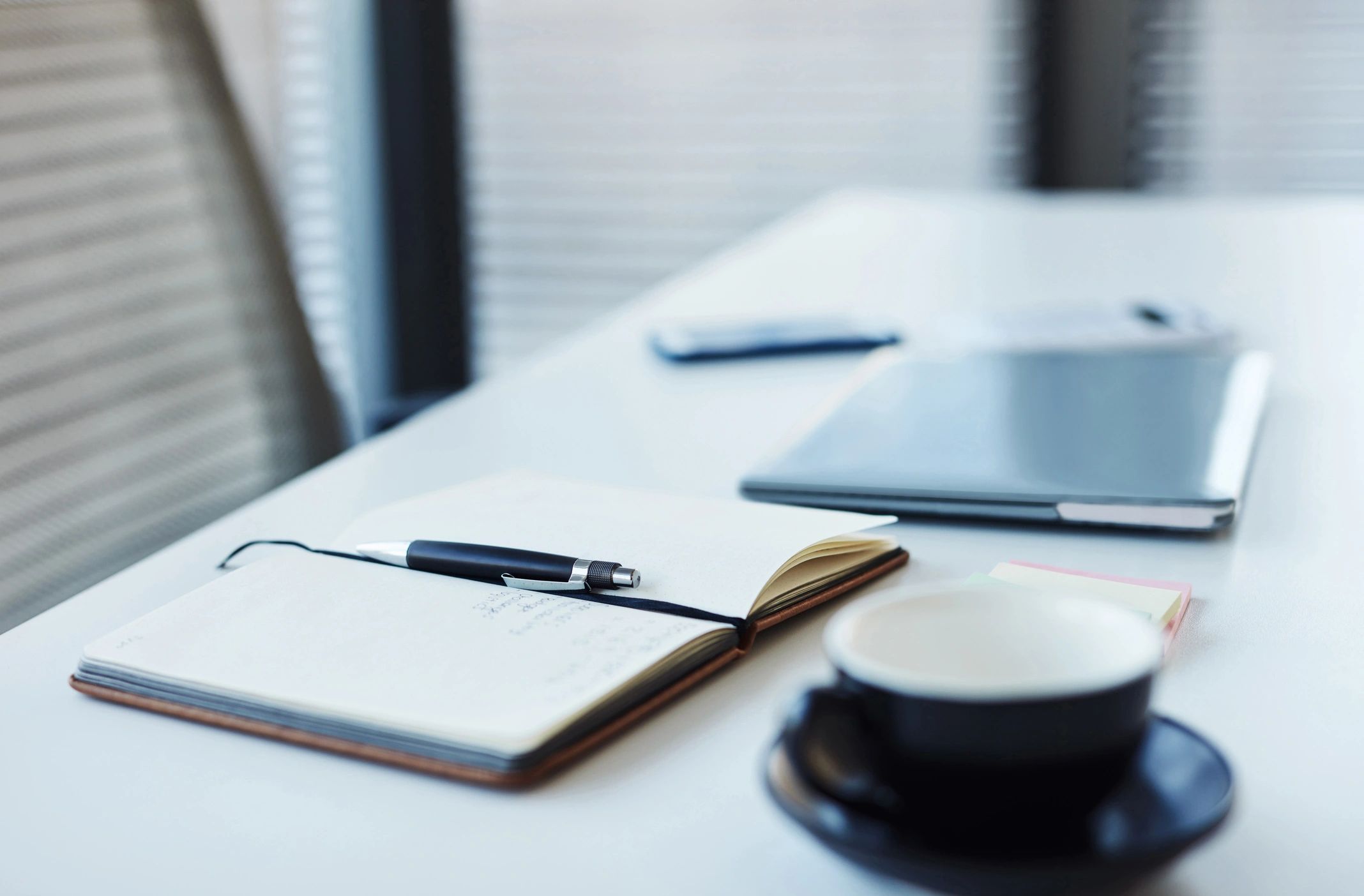 Notebook and laptop arranged on an office desk