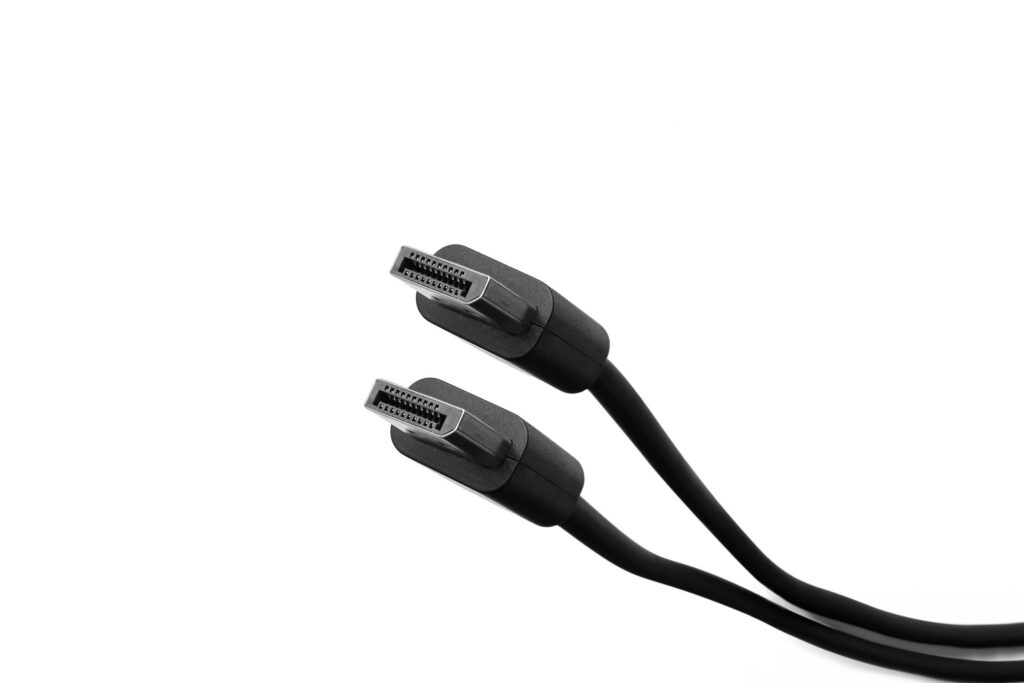two black DisplayPort cables with male connectors, positioned diagonally against a clean, white background