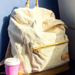 Travel Backpack with Coffee Cup on Train Seat. Ready for Trip, Solo Travel, Adventure and Exploration on Journey.