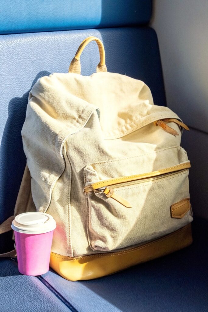 Travel Backpack with Coffee Cup on Train Seat. Ready for Trip, Solo Travel, Adventure and Exploration on Journey.