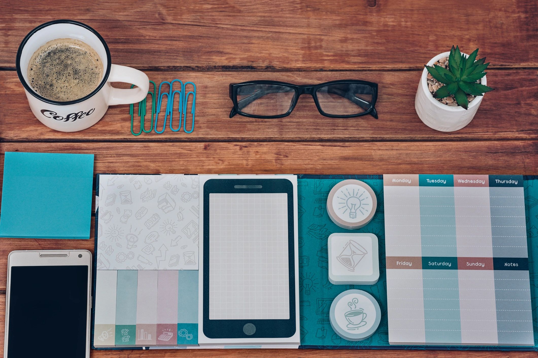 Weekly agenda and office supplies on a desk