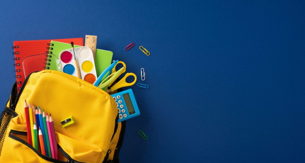 Yellow backpack filled with colorful school supplies and art materials for back to school creativity