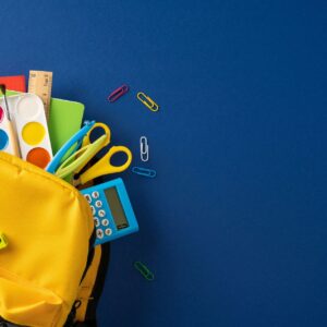 Yellow backpack filled with colorful school supplies and art materials for back to school creativity