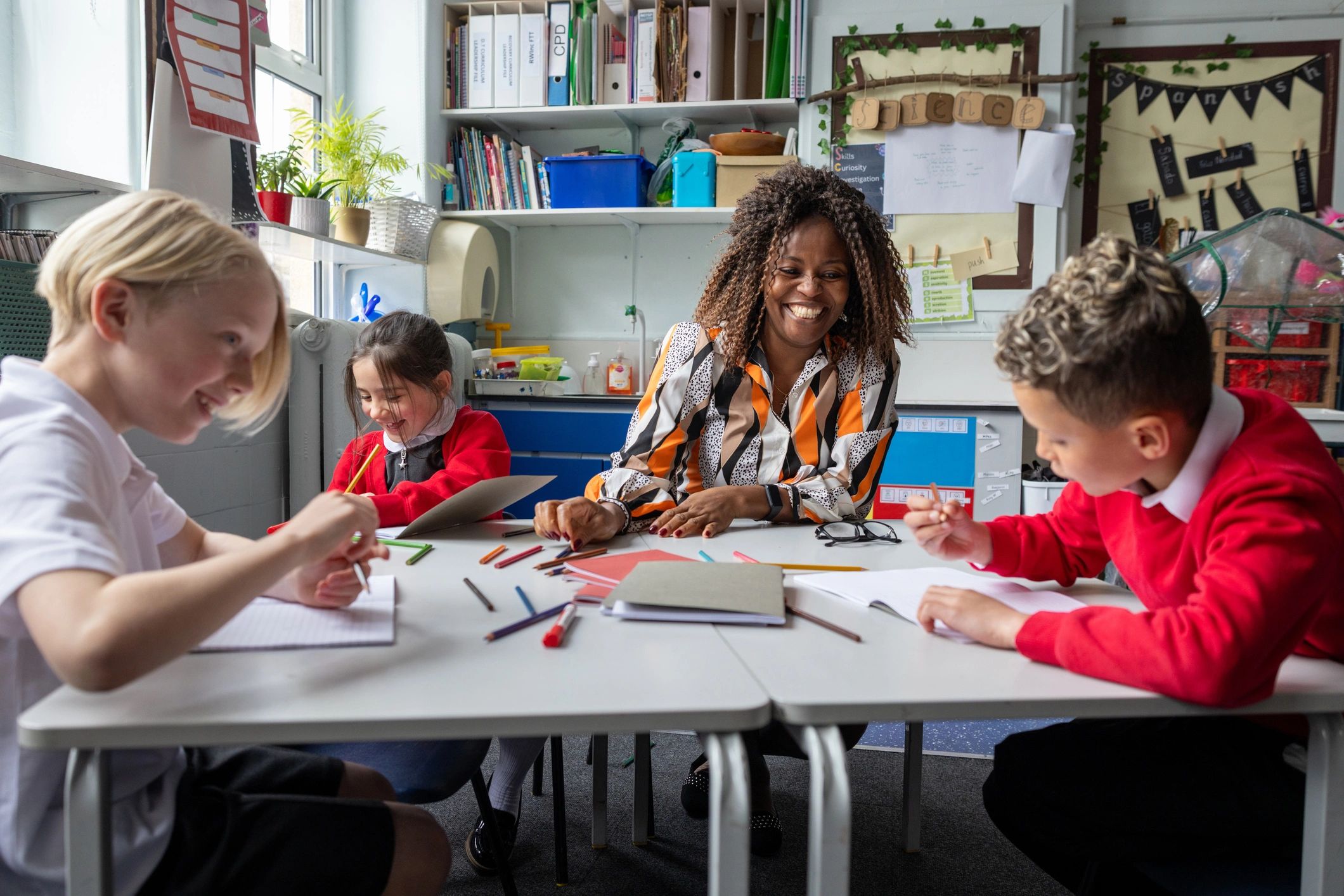 Teacher helping students in a bright classroom