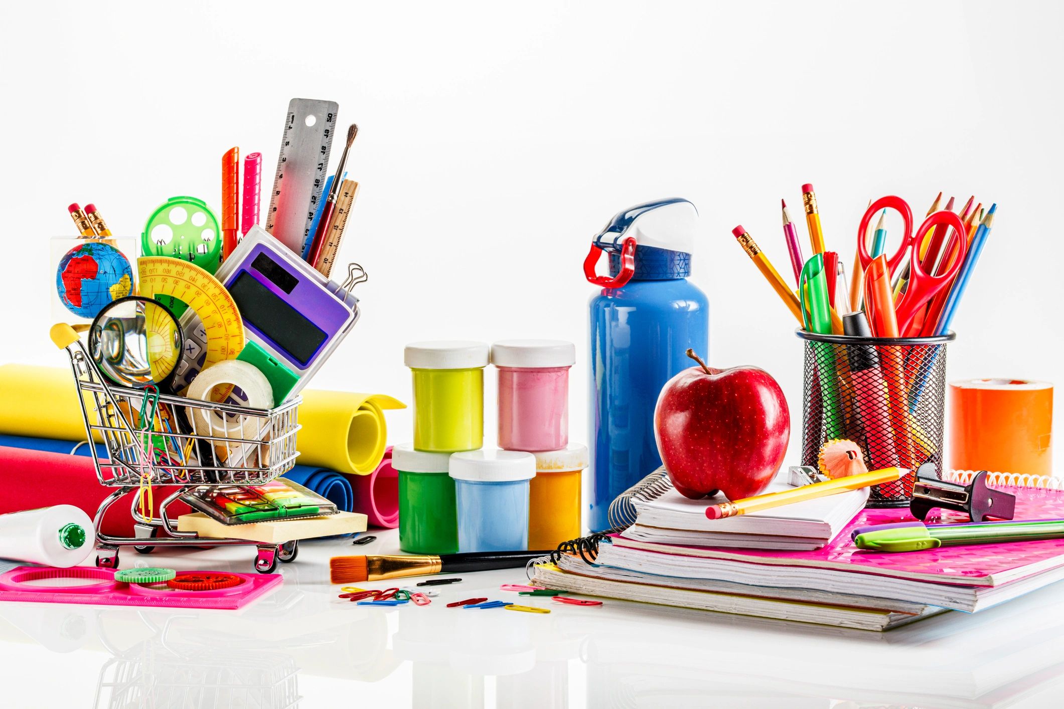 High angle view of stationery and back to school office supplies. A miniature shopping cart.